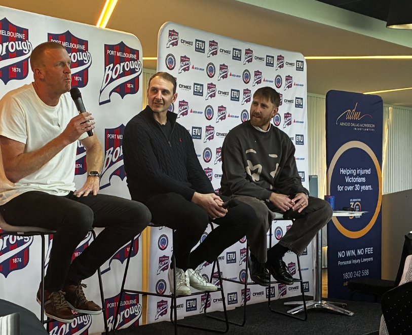 Hosts on stage at Port Melbourne FC Past Players & Official Annual Luncheon in from of ADM banner